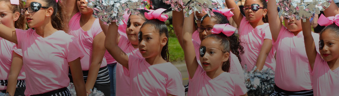 Showing a group of young cheerleaders marching in the Children's parade.