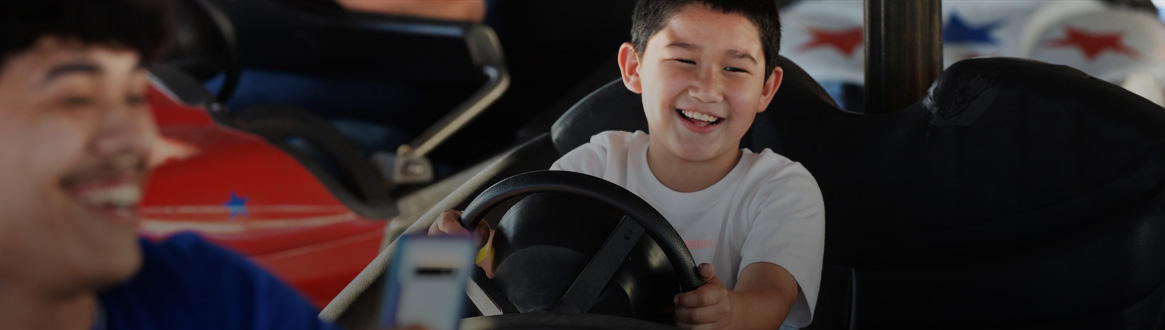 Showing a young boy driving a go kart.